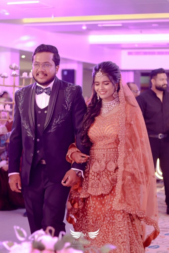 Bride and groom standing on a beautifully decorated wedding stage with floral backdrop and ambient lighting, arranged by expert event planners near me.