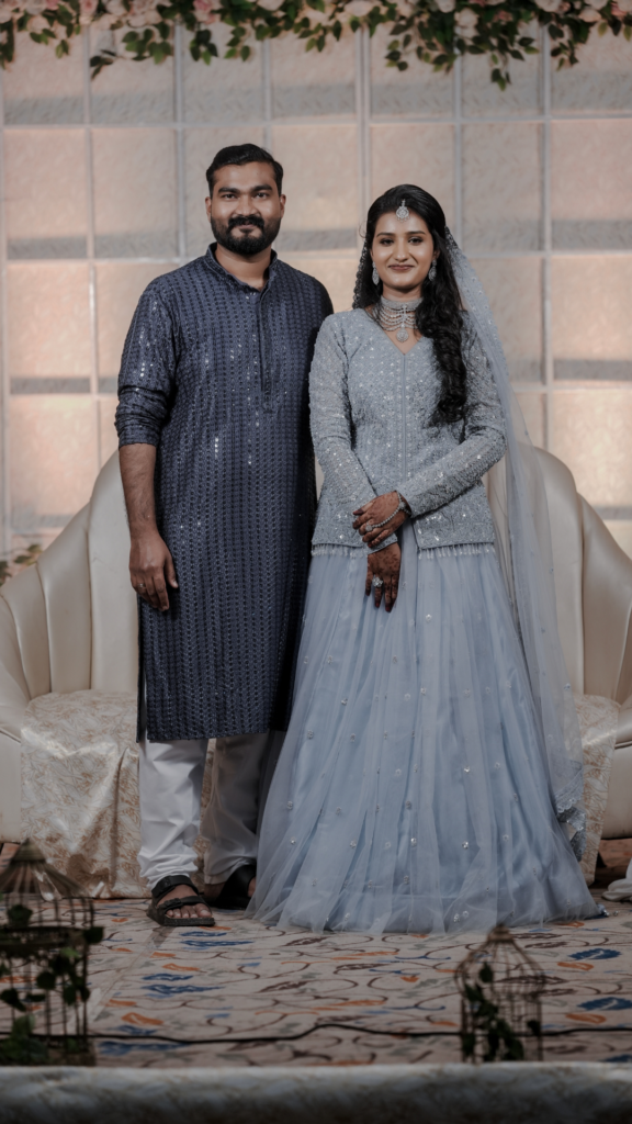 Bride and groom standing on a beautifully decorated wedding stage with floral backdrop and ambient lighting, arranged by expert event planners near me.